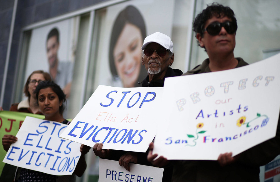 Activists and tenants of 1049 Market Street hold signs as they stage a protest against the landlord's attempts to evict them from the building on March 8, 2016 in San Francisco.