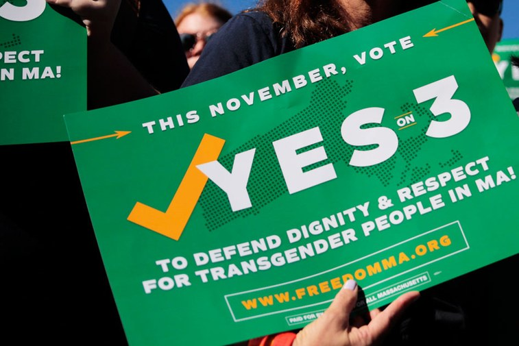 A green protest sign that reads 