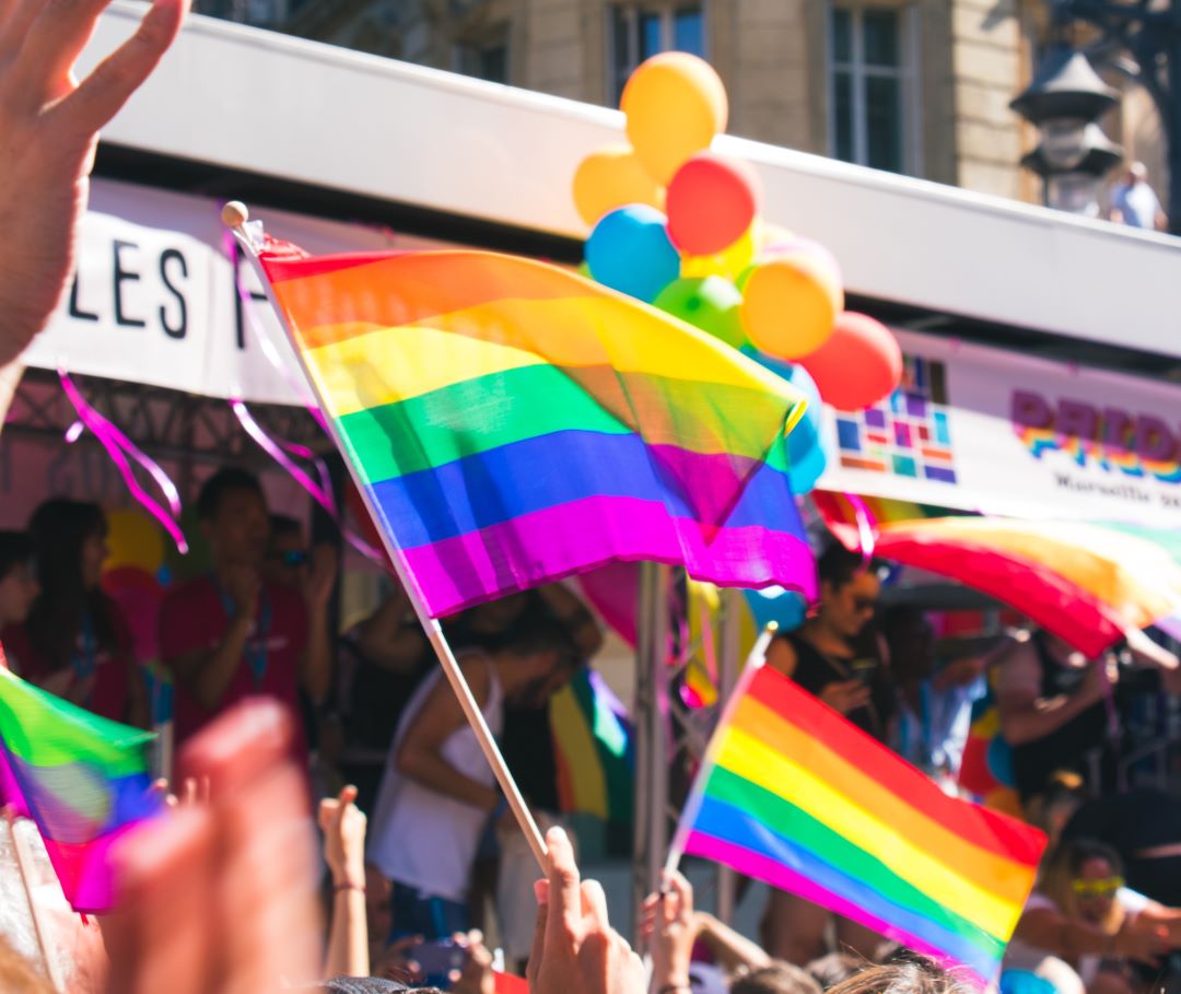 Picture of flags and balloons at a Pride gathering